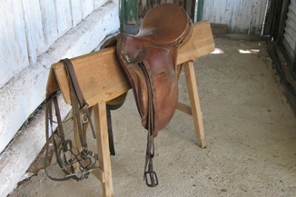 Image of a horse saddle on a timber stand